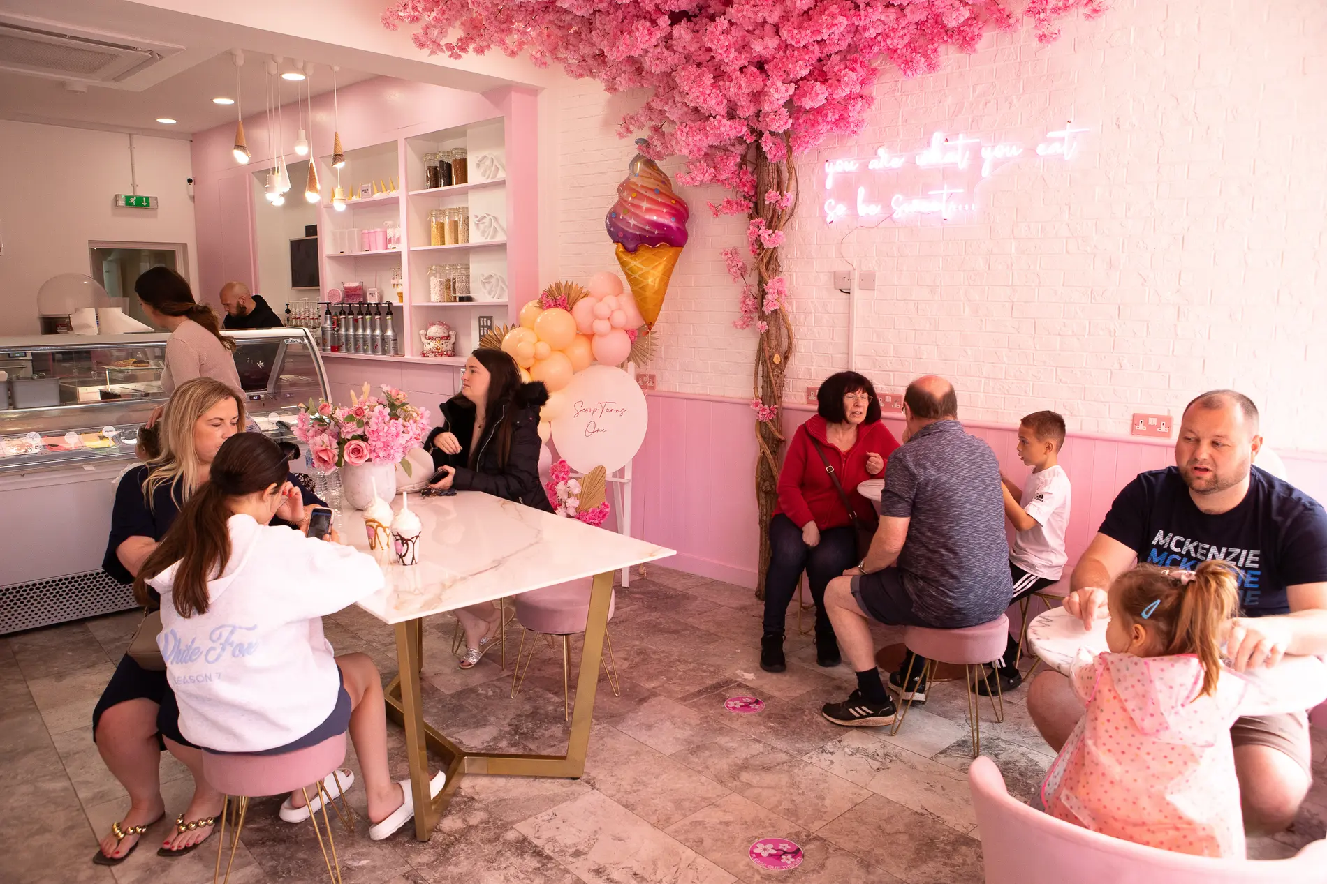 Families, grandparents and children at tables under the blossom tree